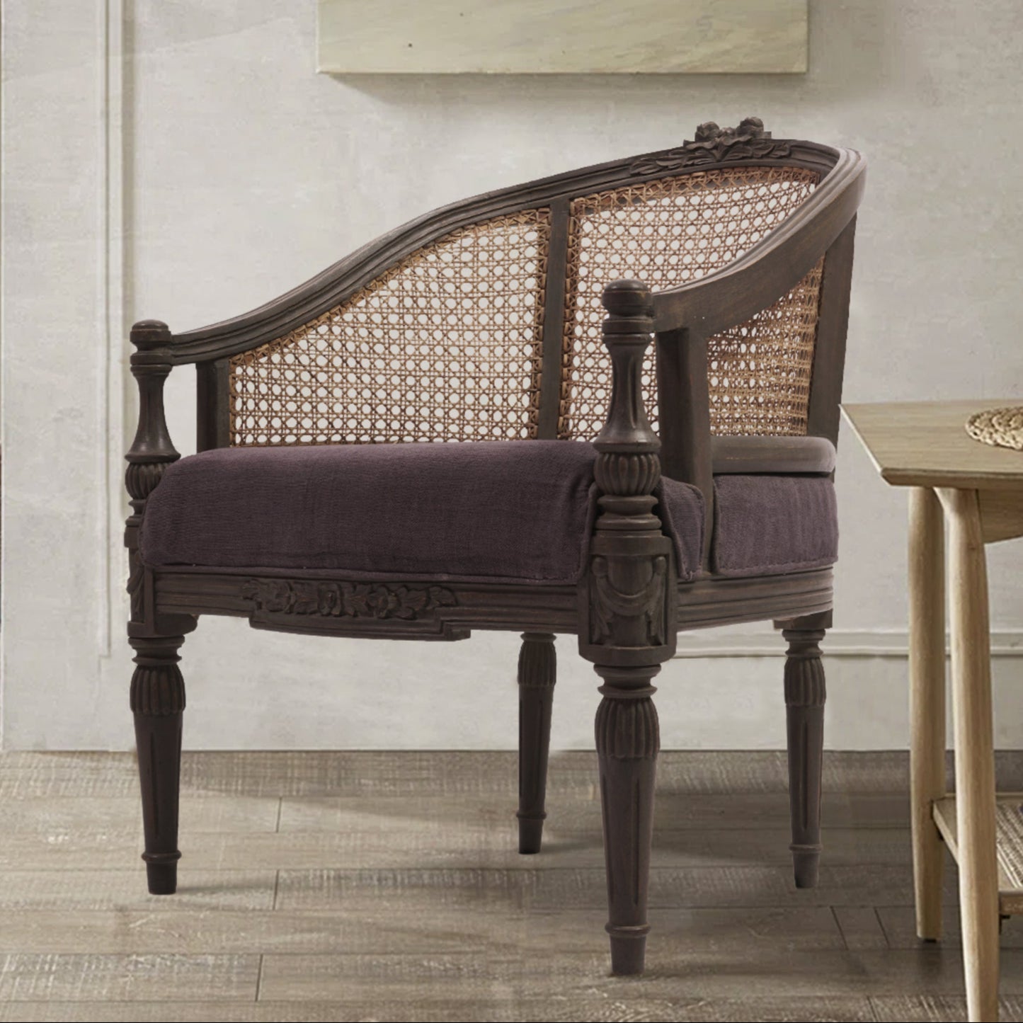 An elegant Rose Chair with a grey textured finish, featuring a comfortable seat and a stylish back, placed in a well-lit room with a painting on the wall and a lamp.