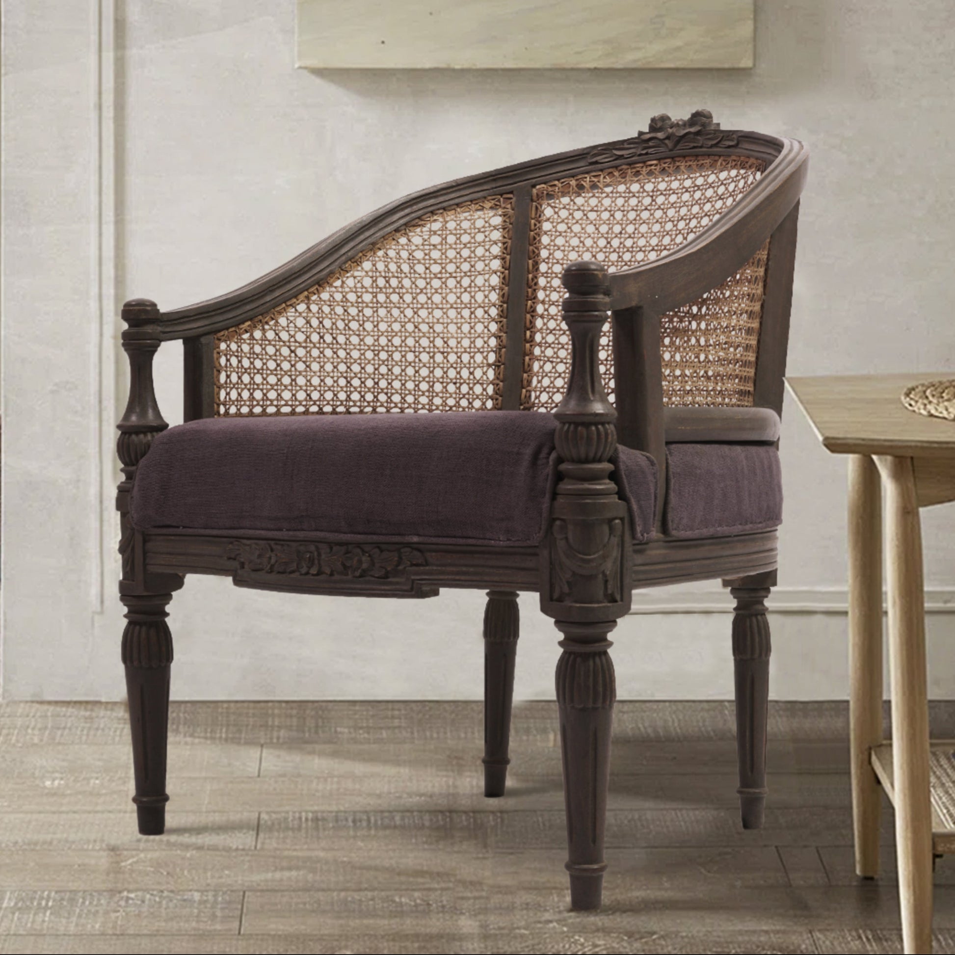 An elegant Rose Chair with a grey textured finish, featuring a comfortable seat and a stylish back, placed in a well-lit room with a painting on the wall and a lamp.